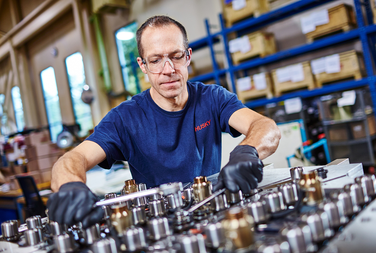  Técnico de Husky haciendo el mantenimiento de un sistema de inyección de moldes médicos